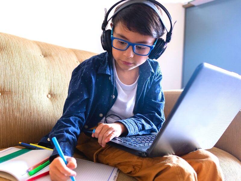 boy in front of computer doing homeschooling