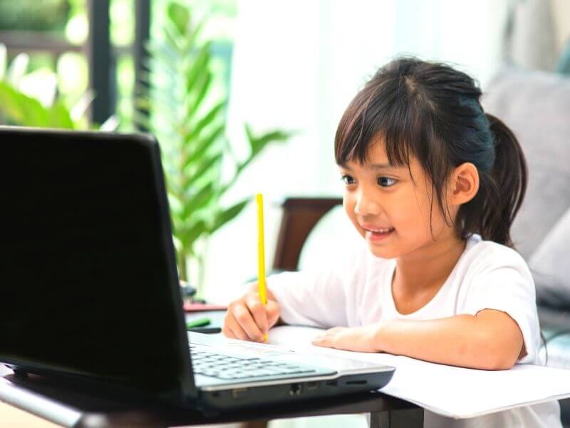 girl learning how to read in front of computer